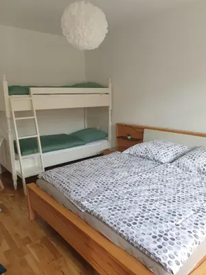 Ein Bett oder Betten in einem Zimmer der Unterkunft Chemnitz Saxonia HomeDeLuxe Hochwertige 50qm 2-Zimmer-Ferienwohnung mit privaten Kfz Parkplatz Stellplatz mit MWSt-Rechnung mit XXL Hülsta Bett & Etagenbett mit InternetFlatrate - Ideal für Familien, Paare, Kulturinteressierte & Geschäftsreisende!