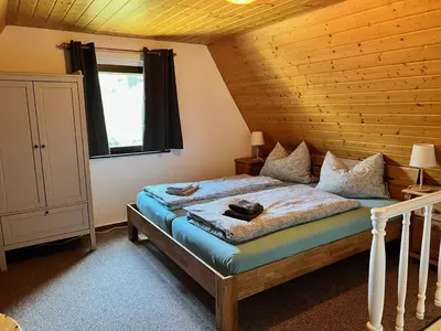Ein Bett oder Betten in einem Zimmer der Unterkunft Urige Berghütte mit Kamin und Sauna im Erzgebirge nahe Schwarzwassertal