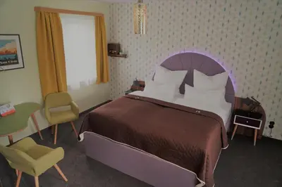 Ein Bett oder Betten in einem Zimmer der Unterkunft Themenhotel 50's Ville Motel