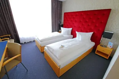 Ein Bett oder Betten in einem Zimmer der Unterkunft rugs Hotel am Schlosspark Lichtenwalde